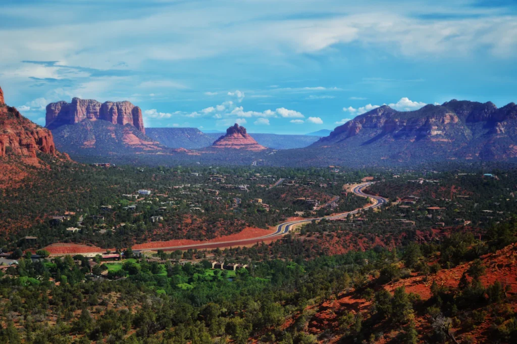 A road winds through Sedona beneath red-rock formations