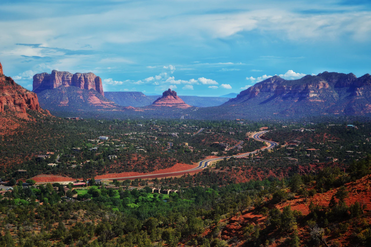 A road winds through Sedona beneath red-rock formations